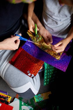 Kız ve baba evde kanepede el sanatları yaparken eğleniyorlar. Makasla kağıt kesiyorlar, karanlık ışık, babalar günü, aile..