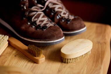 Düz yatış, üst görünüm ayakkabılar süet ayakkabı bakım aksesuarları, ahşap masada fırça. Ayakkabı bakımı yakalandı, metin için kopyalama alanı.