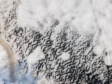 İnsansız hava aracı görüntüsü nehirde eriyor, buz çatlağı, buzullar ve buzdağı manzarası, Top view, doğal kış arka planı. Donmuş suyun buz yüzeyinde çatlak. Küresel sıcaklık