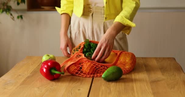 Mujer Chaqueta Amarilla Desempaquetando Bolsa Ecológica Malla Compras Con Verduras — Vídeos de Stock