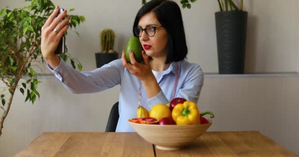 营养学家 营养学家 在智能手机上记录她关于健康饮食 保健和饮食概念的博客 有水果在家中工作的女营养师 — 图库视频影像