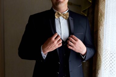 Yakışıklı, zarif, şık, smokinli, klasik takım elbiseli, papyonlu, siyah smokinli ve papyonlu genç adam.