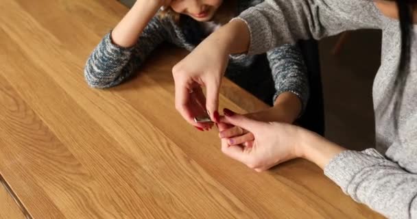 母は彼女の女の子の娘の爪を自宅でクリッパーで切るのを助け 女性は子供の爪を切る 家族の愛とケア — ストック動画