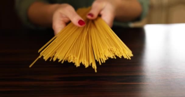 家庭のキッチンでイタリア人の調理されないスパゲティ全粒パスタを保持女性の手 イタリア料理 — ストック動画