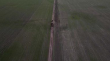 Modern sarı traktörün tarlalarda sürüşü, tarlayı sürüşü, araziyi ekime hazırlama, insansız hava aracı videosu..