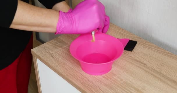在家里准备染发的时候 穿着粉色手套的无法辨认的女人把颜料挤在碗里 — 图库视频影像