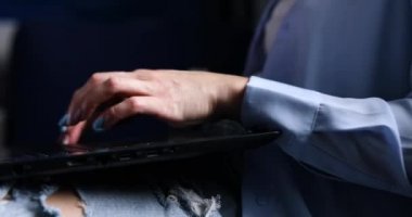 Tanınmayan kadın elleri dizüstü bilgisayarda klavye kullanıyor, çalışıyor, e-posta yazıyor, kenar görüşlü, serbest çalışan, evdeki kanepede oturan defter üzerinde çalışıyor.