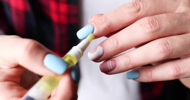 Gros plan des mains féminines avec une belle manucure appliquer de l'huile sur les cuticules des doigts — Video