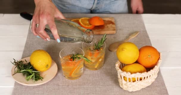 La mano femminile versa l'acqua in occhiali, facendo la limonata fresca — Video Stock