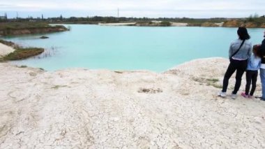 Göl kıyısındaki seyahat ailesinin üzerinde alçaktan uçan İHA.