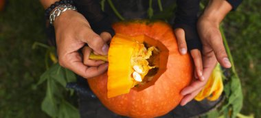 Kız ve baba ellerini açar Cadılar Bayramı için oymadan önce balkabağı keser Jack O 'Lantern' i hazırlar. Parti için dekorasyon, Küçük aile yardımcısı, Üst Manzara, Kapat, Yukarıdan görünüm, Boşluğu kopyala