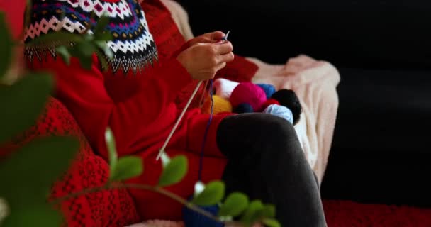 Mujer madura sentada en un cómodo sofá y tejiendo — Vídeo de stock