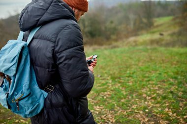 Sırt çantalı gezgin elinde pusula ile dağların arka planında doğa nehri seyahat konsepti, kamp gezisi, GPS, yön bulma, seyir subayı.