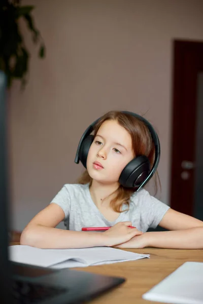 Cute Little Girl Słuchawkami Pomocą Laptopa Nauki Domu Pisanie Odpowiedź — Zdjęcie stockowe