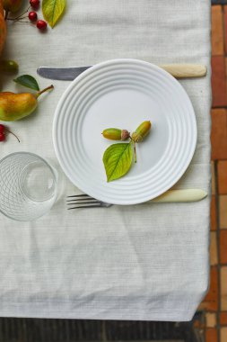 Şükran Günü ya da Cadılar Bayramı yemek masası. Kabak, meşe palamudu, armut yaprakları beyaz masa örtüsü armut, yukarıdan manzara, düz yatış.