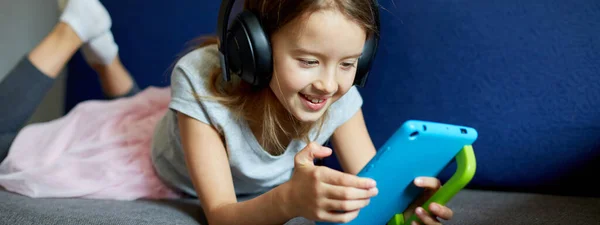 Banner Linda Niña Los Auriculares Acostado Sofá Con Computadora Tableta — Foto de Stock