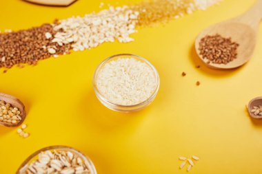 Yığınla tahıl, bulguru, pirinç, yulaf, karabuğday, sarı zemin üzerinde kuskus tohumu, metin için yer, metin için yer, üst görünüm.