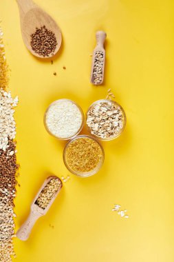 Yığınla tahıl, bulguru, pirinç, yulaf, karabuğday, sarı zemin üzerinde kuskus tohumu, metin için yer, metin için yer, üst görünüm.