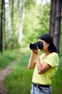 Yüzünü kamerayla kapatan bir kadın fotoğrafçının portresi dünya fotoğrafçıları günü elinde fotoğraf makinesi olan genç bir kadın..