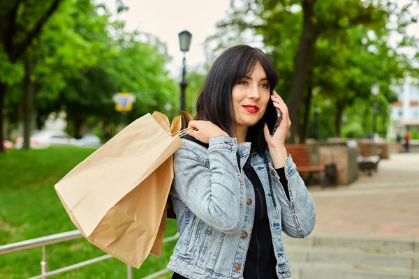 Brunetka Trzyma Papierowe Torby Zakupy Rozmawia Przez Telefon Rozmawia Przez — Zdjęcie stockowe