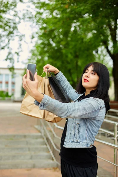 Brunetka Kobieta Trzyma Papierowe Torby Zakupy Robi Selfie Przez Smartfona — Zdjęcie stockowe