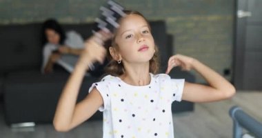 Güzel küçük kız aynanın önünde saçlarını tarıyor.