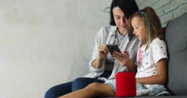 Anne ve kızı test ediyor. Akıllı telsiz hoparlörü konuşuyor.