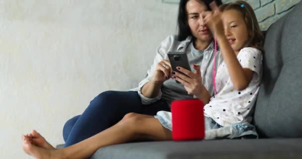 Madre e hija probando el altavoz inalámbrico inteligente que habla — Vídeo de stock