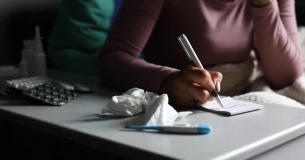 Нездоровая дама вытирает нос и вызывает врача, чтобы написать квитанцию о лекарстве — стоковое видео