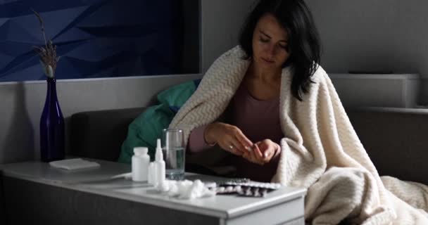 Mujer enferma poniendo la medicina en la mano y tomarla, bebiendo agua mientras se recupera en casa — Vídeos de Stock