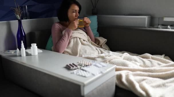 Langzame beweging van zieke vrouw die mok warme duindoorn thee vasthoudt — Stockvideo
