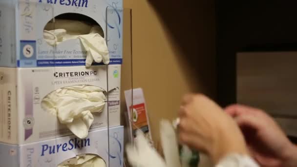 Krankenschwester zieht Latex-Handschuhe an
