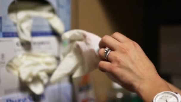 Sjuksköterska att sätta på latexhandskar — Stockvideo