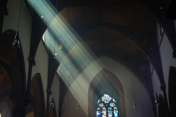 Light shafts stream into church window — Stock Photo, Image