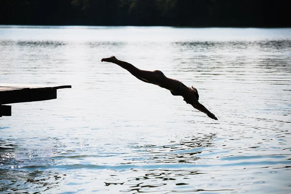 Mujer saltando en el lago — Foto de Stock
