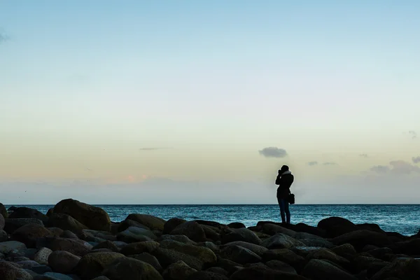 Mujer feliz fotografiando el mar en la playa —  Fotos de Stock