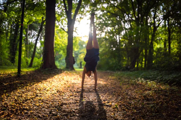 symbol of vitality Handstand in a forest, blurred