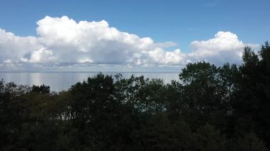 Güzel beyaz bulutlar mavi gökyüzü arkaplanı ile denizde yansıyor.