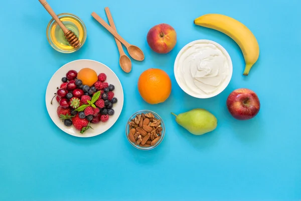 Joghurt és gyümölcsök, bogyós gyümölcsök, dió, méz, mint az összetevők. — Stock Fotó