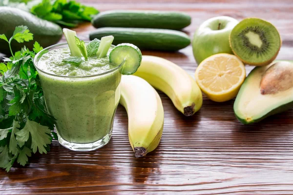 Green vegetable smoothie and ingredients.