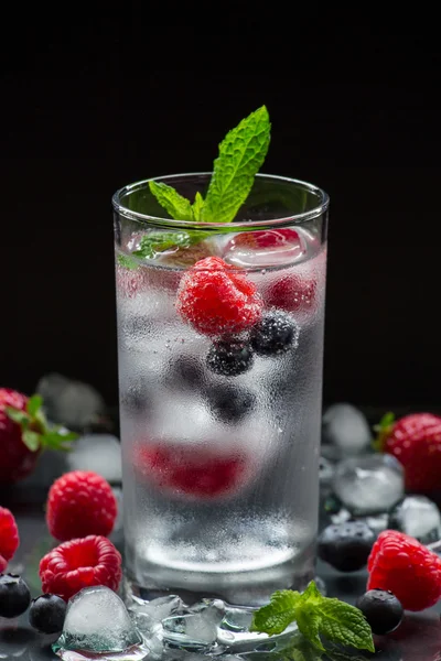 Agua mineral con bayas y cubitos de hielo . —  Fotos de Stock