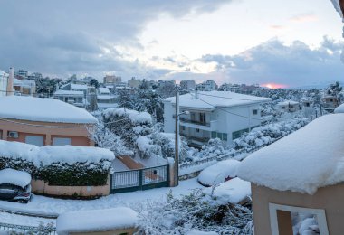Atina şehir-Yunanistan sokaklarının karla kaplı çatı ve caddelerinin panoramik manzarası günbatımından önce güzel bir kış akşamı.