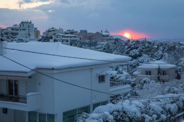 Atina şehir-Yunanistan sokaklarının karla kaplı çatı ve caddelerinin panoramik manzarası günbatımından önce güzel bir kış akşamı.