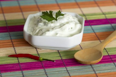 taze sarımsak daldırma sos biber ve dekoratif bir arka plan üzerine bir tahta kaşık kase