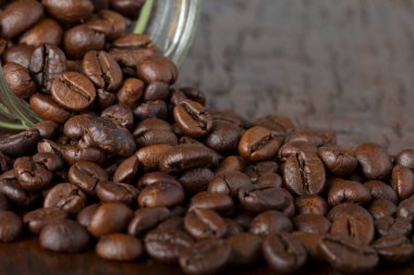 Ahşap masa üzerinde kahve çekirdekleri ile Cam Kavanoz