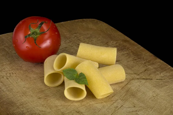 Paccheri makarna domates ahşap zemin üzerine