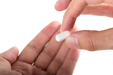 Adam el beyaz arka plan üzerinde izole hastaya bir hap vererek