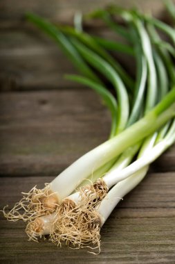 Bir ahşap tahta üzerinde taze scallions demet