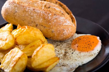 Bir sahanda yumurtayı patates ve ekmekle kapatıyoruz.