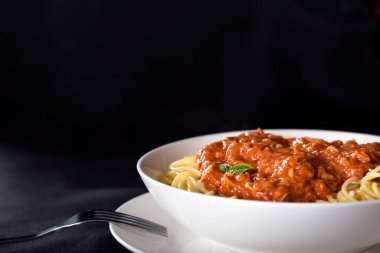 Kopya alanı ile siyah arka plan üzerinde ton balığı soslu spagetti
